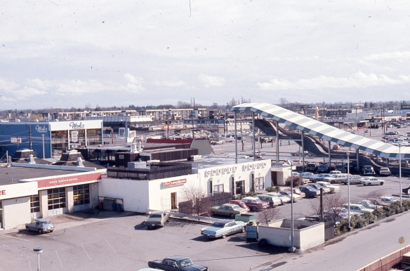 This image, looking south east toward No.3 Road in 1973, shows the Skookum Slide on the right, the back of the Richmond Savings Credit Union in the centre and Wosk's Furniture on the left. The red roof of the Dairy Queen can be seen above the Credit Union. City of Richmond Archives photo 2008 39 2 34.